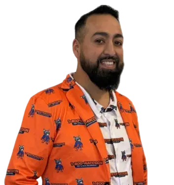 Portrait of a smiling 1-800-RACCOON technician wearing a highly branded orange raccoon mascot jacket.